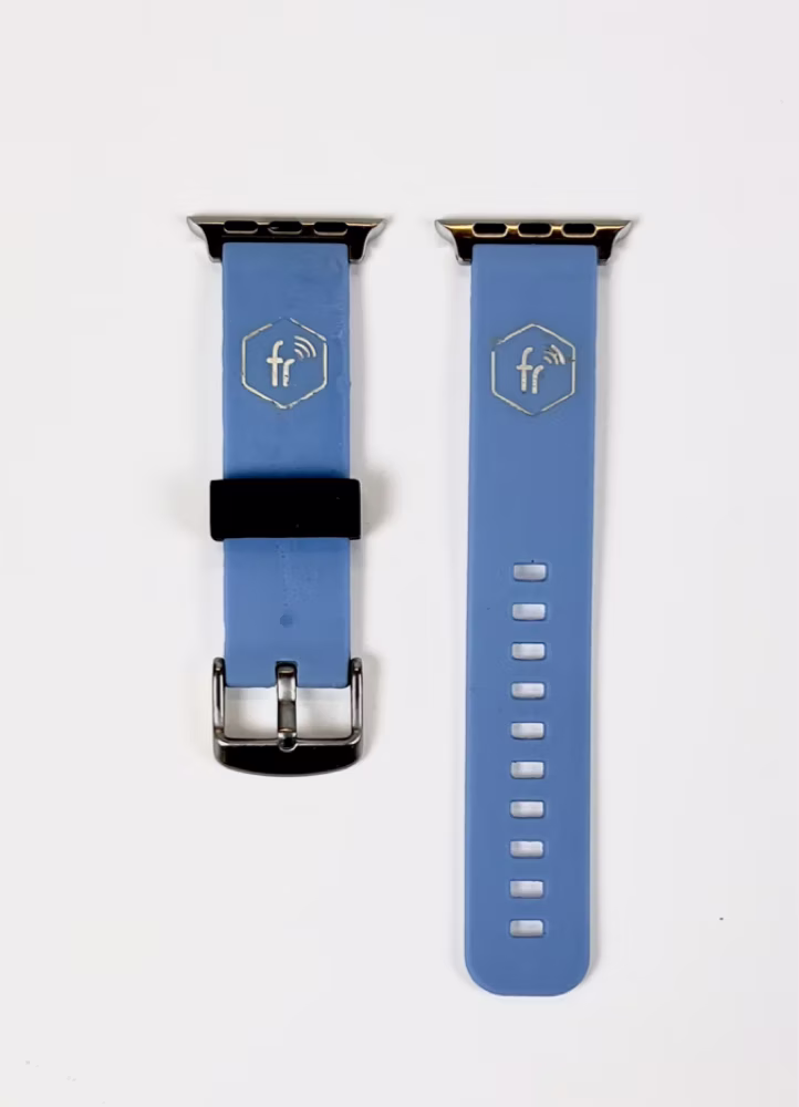 The two halves of the blue prototype band laid flat, each marked with the fobbr hexagon logo over an embedded RFID chip